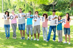 Friends holding placards spelling volunteer